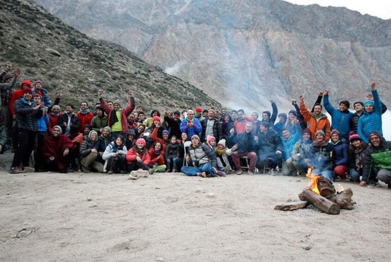 Grupo grande personas reunidas frente a una fogata