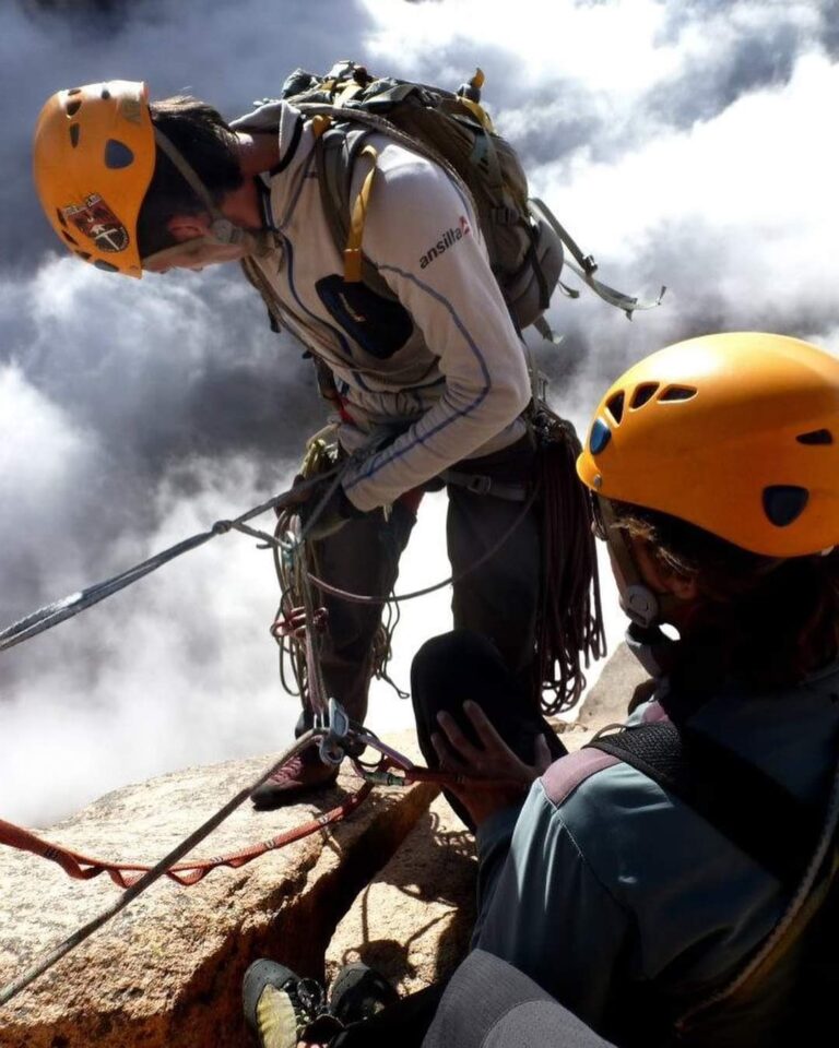 Dos escaladores realizando tareas de rapel desde la parte alta de una aguja
